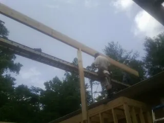 Carpenter setting a ridge beam over a new addition frame — Ice Dam Removal by Roofing Brothers in Onancock