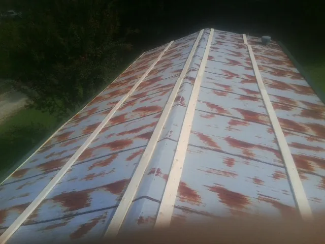 Rusted metal roof panels with new wood purlins before replacement — Storm Damage Roof Repair in Onancock by Roofing Brothers
