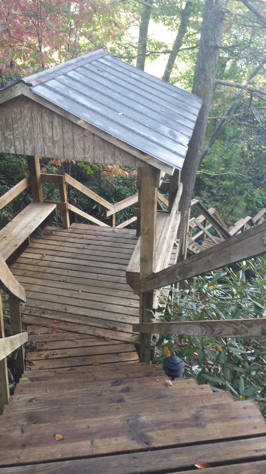 Metal roofed shelter over wooden steps on a wooded walkway — Skylight Repair & Installation work by our crew in Onancock