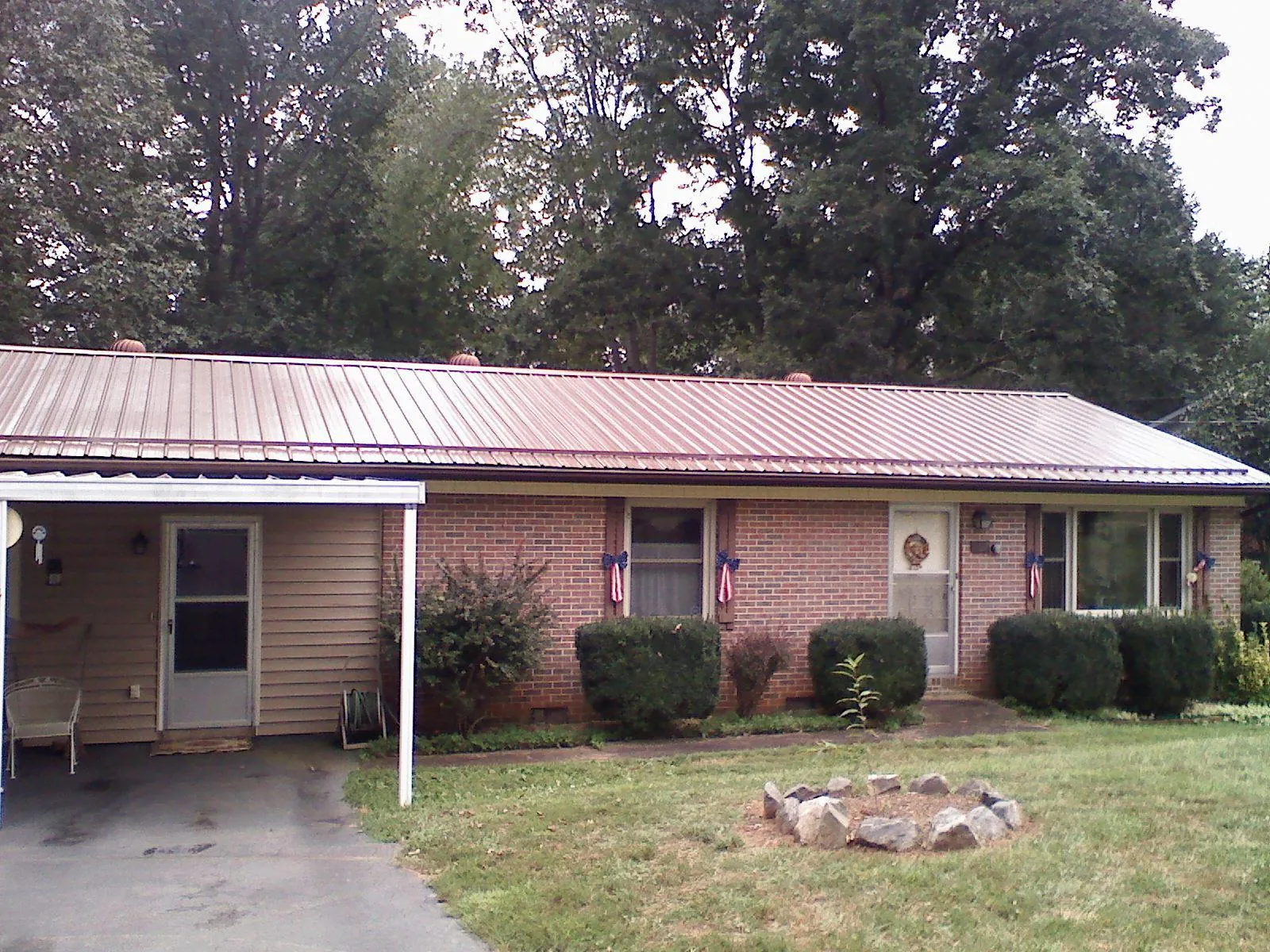 Bronze metal roof and carport on a brick ranch home — Roof Repair work by our crew in Onancock
